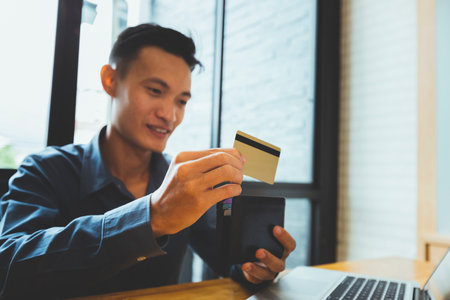 Businessman holding credit card and wallet. Making payment while online shopping. E-commerce and...