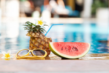 Summer holiday tropical concept. Fresh  water melon and pineapple on border of a swimming pool.
