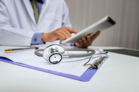 Close-up of stethoscope is lying on the clipboard in front of  a doctor.の写真素材