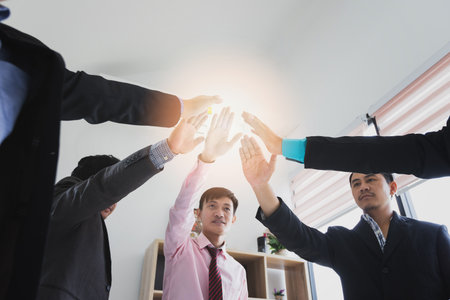 Concept of teamwork: Close-Up of hands business team showing unity with putting their hands...