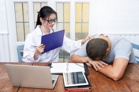 Doctor holding patient's shoulder for encouragement, empathy, cheering and support while medical examination. Bad news lessening, medicine and health care concept.の写真素材