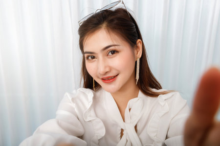 Young asian woman traveler blogger selfie herself with smart phone while recording vlog video live streaming.の写真素材