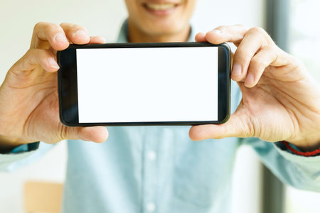 Man holding smartphone in hand. Business man showing smartphone.の写真素材