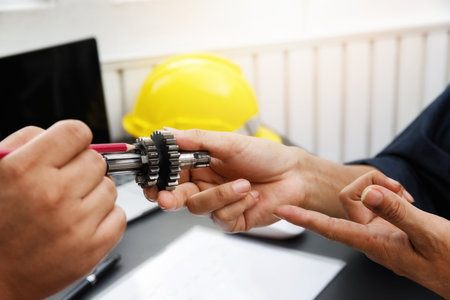 The engineering team point to the gear and discussing on their project together.の写真素材