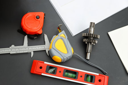 Top view of gear with measurement tool, tape, level and vernier caliper on engineer desk.