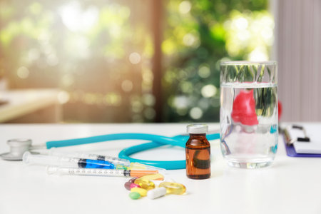 Medicine, syringe, injection and stethoscope on a white wooden table. Medical and Health care or illness concept.の写真素材
