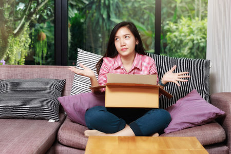 Woman raised her palm with parcel box and feel disappointed after received damaged item or unwanted...