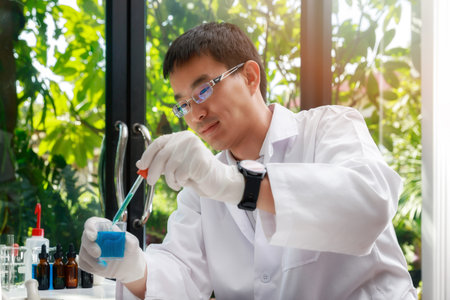 Researcher or scientists loads liquid sample into test tube in laboratory. Researcher or scientists working in laboratory. Researchers are inventing vaccines to treat COVID-19 virus.の写真素材