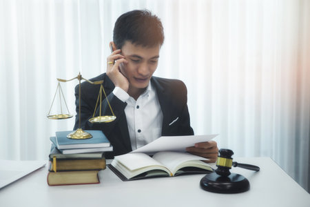 Asian male lawyer reading documents in his home office.の写真素材