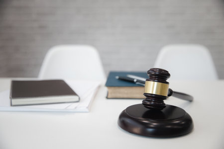 Wooden gavel and books on table in lawyer's office.