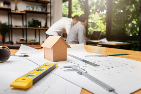 House model on desk over confident team of architects working together in a office. Architect discuss with engineer about project in office, architectural concept.の写真素材