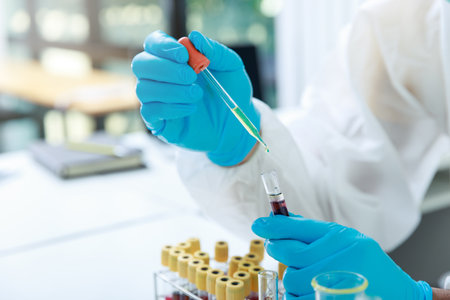 Researcher or scientists loads liquid sample into test tube in laboratory. Researchers are...