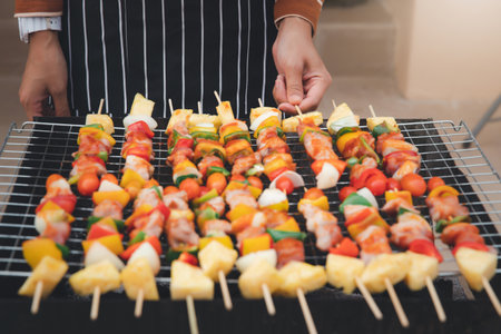 A woman grilling barbecue in dinner party. Food, people and family time concept.の写真素材