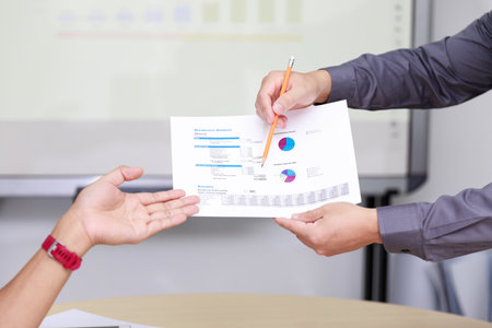 Businessman present the monthly college budget to his colleagues during meeting.の写真素材