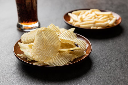 Potato chips, French fries snack and a glass of cola. Food and drink concept.
