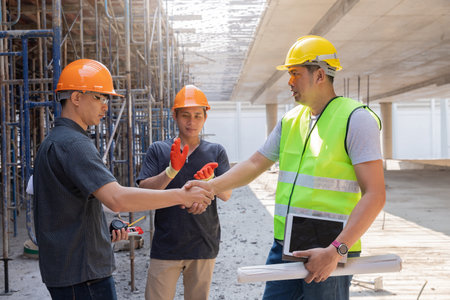 Teamwork, partnership, gesture concept. Builders greeting each other with handshake on construction...