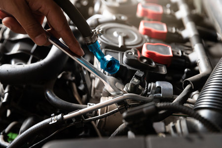 Auto mechanic man with wrench repair and maintenance to customer the engine a vehicle car hood in...
