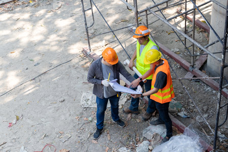 Confident team of architect working together in building construction site. They discussing about...