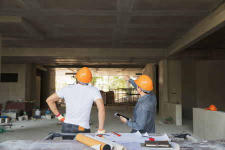 Confident team of architect working together in building construction site. They discussing about...