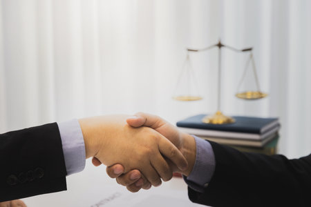 The lawyer shook hands with the client after completing the consultation in the case.の写真素材