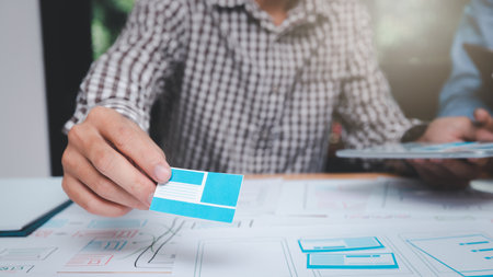 UX or UI designers designing on their smartphone application layout prototype project.