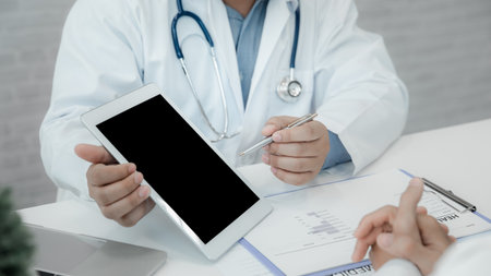 A doctor consulting and explain patient health check via digital tablet in office. Medicine and...