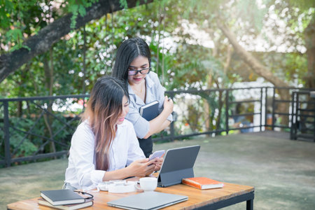 Business team meeting and discussing project plan. Businesswomen discussing together in cafe co-working space. Professional investor working with business project together. Finance managers task.の写真素材