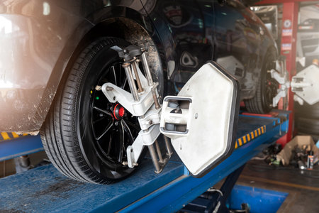 Car wheel balancer calibrate with laser reflector attach on each tire to center driving adjust. Car in auto service. Balancing tire wheel machine.の写真素材