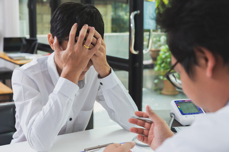 Patient man with depression crying during psychotherapy session.の写真素材