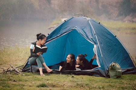 Group of Asian pretty girls camping by the tent. Outdoor activity, adventure travel, holiday vacation concept.の写真素材