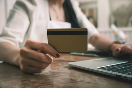 Businesswoman holding credit card and using laptop. Making payment while online shopping. E-commerce...