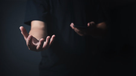 Male empty hand open a palm up on a dark background.の写真素材