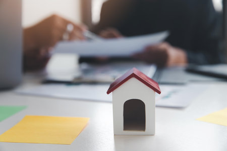 House model on desk over confident team of architects working together in a office. Architect discuss with engineer about project in office, architectural concept.の写真素材