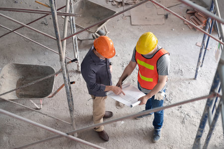 Top view of Confident team of architect working together in building construction site. They discussing about new startup project. Architect discuss with engineer about project.の写真素材
