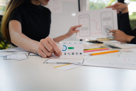 Female ux developer and ui designer brainstorming about mobile app interface wireframe design. App...