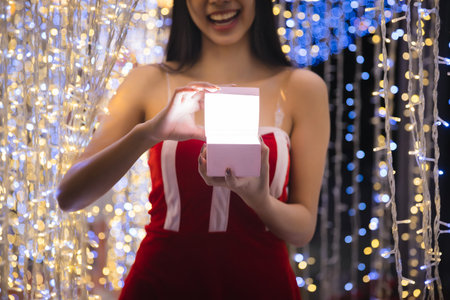 Woman opening magic Christmas Gift box. Beautiful New Year and Christmas scene. Miracles and wishes come true on Christmas eve.の写真素材