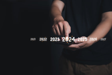 Man Finger pressing on start year 2024 button on smartphone with copy space for text. Concept of new year. Businessman pressing 2024 start up business. Beginning of New Year 2024.の写真素材