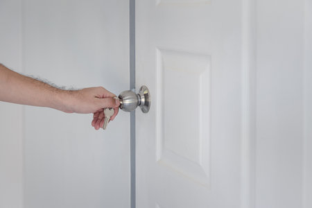 Man hand use key opening the white door. A man unlocking the door with a key.の写真素材