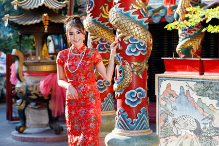 Chinese woman in red cheongsam dress at shrine. Concept to celebrate Chinese New Year.の写真素材
