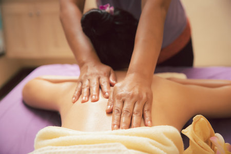 close-up masseur hands doing back massage in spa salon. Beauty treatment concept.の写真素材