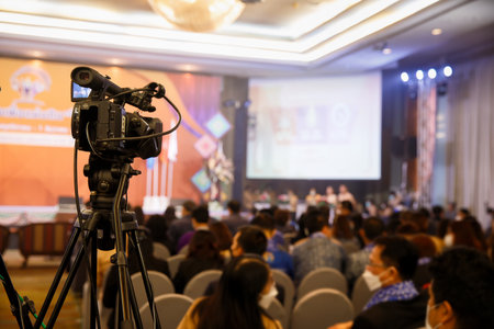 Camcorder while filming. TV camera in conference or seminar. Video camera with blur background.
