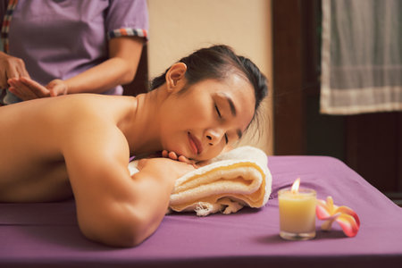 Asian woman enjoying back massage in massage salon. Beauty treatment concept.の写真素材