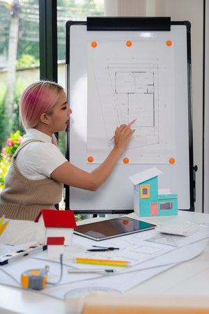 Woman architect making building blueprint plan presentation at work in front of colleague.の写真素材
