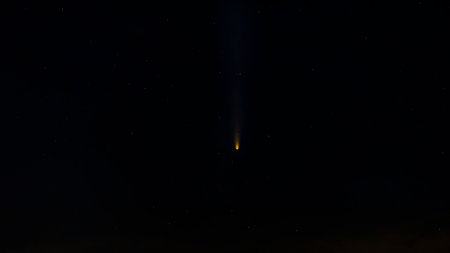 Bright comet C/2023 A3 (Tsuchinshan-ATLAS) streaks across a dark starry night sky, showcasing its glowing tail. A stunning celestial phenomenon captured in deep space.の写真素材