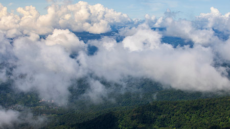 Stunning aerial view of lush green mountains blanketed by a sea of clouds. The serene landscape creates a breathtaking atmosphere, perfect for nature lovers and adventurers.の写真素材