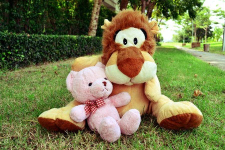 Teddy bear and lion doll hugging in garden vintageの写真素材