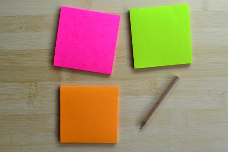 Colorful post it note and wooden  pencil on wooden boardの写真素材