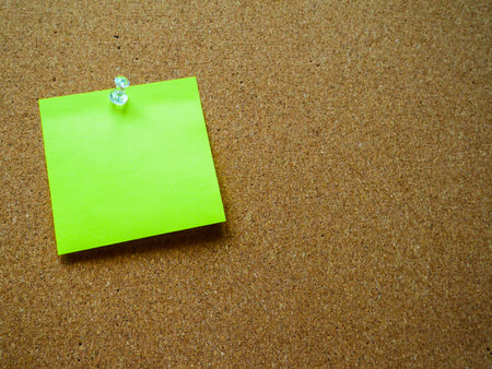 Green post note on wooden board with copy space