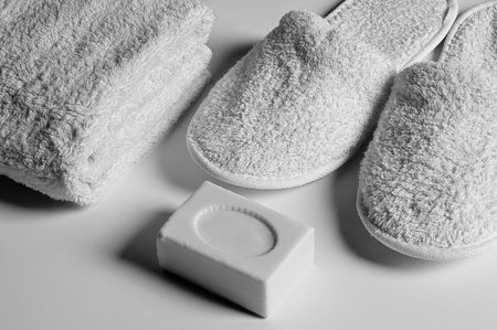 white soap, white slippers and white towel on white backgroundの写真素材