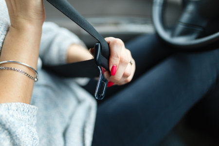 The woman's hand stretches behind the seat belt to fasten it. Safety while drivingの写真素材